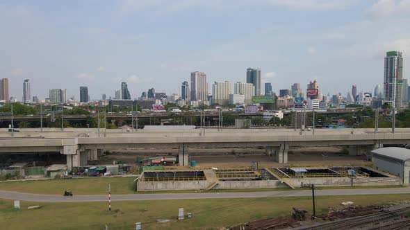 Aerial dolly along Railway viaduct on New Bang Sue Grande Station. Bagkok Skyline Background