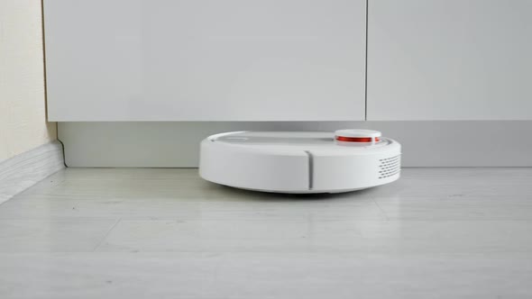 Closeup of a Robot Vacuum Cleaner Driving on the Floor