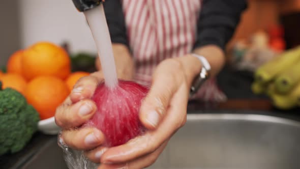 Female Hands Washing Apple Under Water in Sink