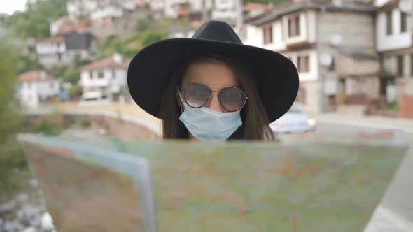 Close Shot of Woman with Face Mask and Sunglasses Exploring Map in Old Town