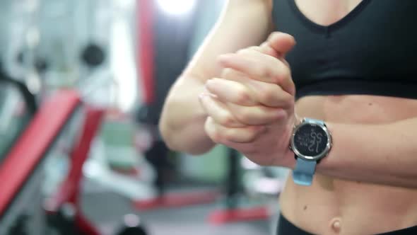 Athletic girl does a warm-up before training in the gym.