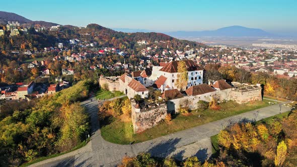 Aerial drone view of The Citadel in Brasov at sunrise, Romania. Medieval fortress on the top of a hi