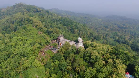 Green hills of Magelang with quirk Chicken Church, Java Indonesia, aerial panorama