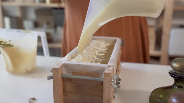 Liquid soap being poured into mold in artisan manufacture