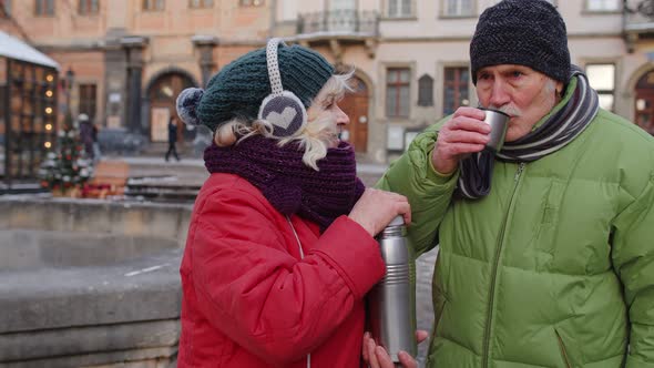 Senior Wife Husband Tourists Drinking From Thermos Enjoying Hot Drink Tea on City Central Street