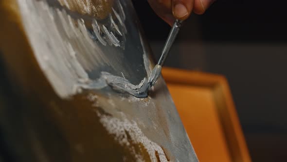 Closeup of the Artists Hands Holds a Brush and Paint on Canvas Oil