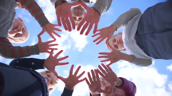 A Friendly Large Family Makes a Circle Shape Out of the Palms of Their Hands. alt