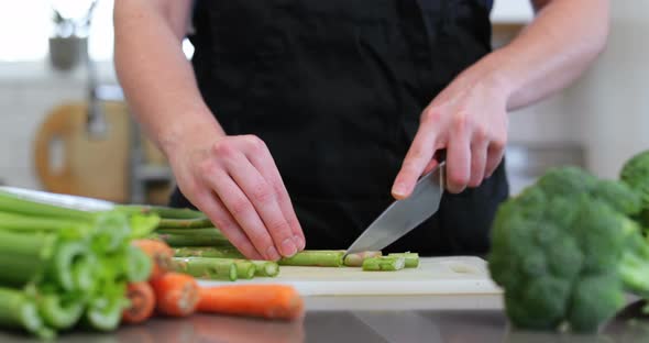 Woman chopping vegetable in kitchen at home 