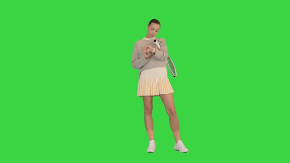 Beautiful Female Tennis Player Looking on Fitness Tracker on a Green Screen Chroma Key