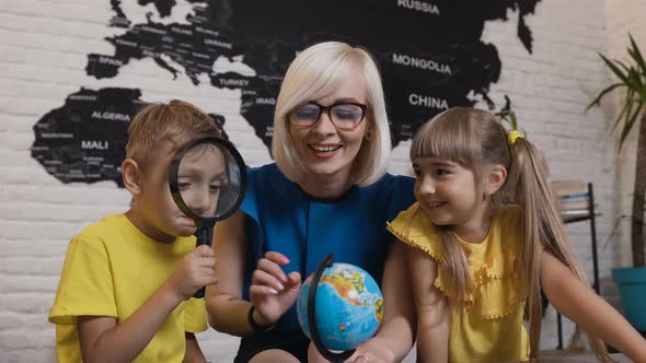 Portrait of the Lovely Two Pupils and Young Teacher in Glasses 