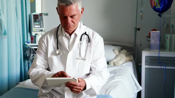 Male doctor using digital tablet in ward