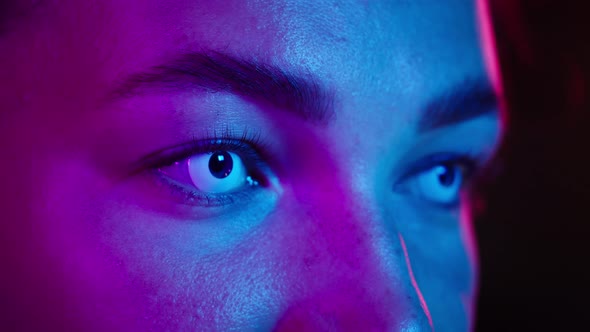 Closeup of Young Woman Wearing White Decorative Lenses in Ultraviolet Light
