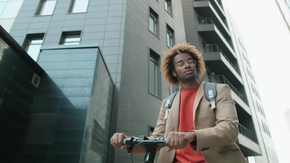 Portrait of Cheerful Afro Man Standing with E-Scooter in City