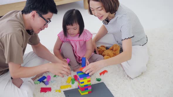 Happy family with mother, father and disabled daughter spending time together at home.