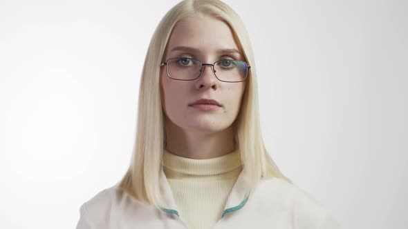 Young Female Dentist in Mask Approaches With Tools Holding a Mouth Mirror and Dentist's Hook