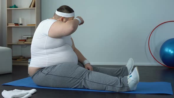 Tired Overweight Man Stretching and Falling Down Mat After Exhausting Training