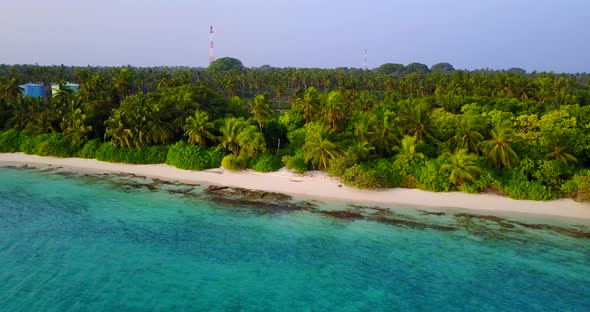 Tropical overhead tourism shot of a sunshine white sandy paradise beach and aqua blue ocean backgrou