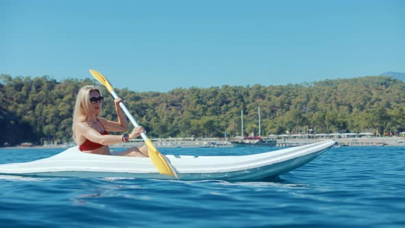 Girl In Kayak Summer Trip. Woman Exploring Calm Sea By Canoe On Holiday Vacation Weekend.