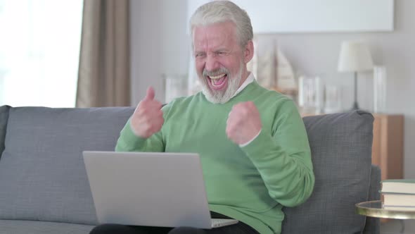 Old Man Celebrating Success on Laptop at Home