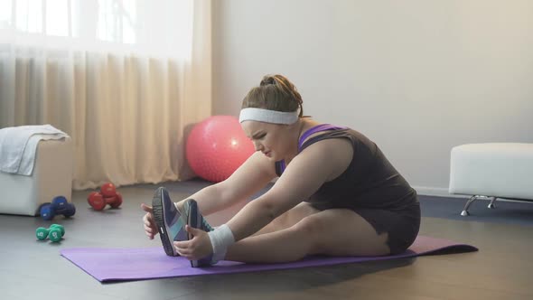 Frustrated Fat Girl With Great Difficulty Trying to Reach Toes, Stretching