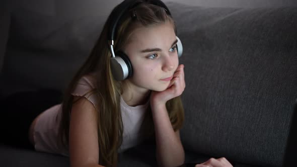 Girl with Headphones Enjoying Online Learning in Front of Her Laptop Computer