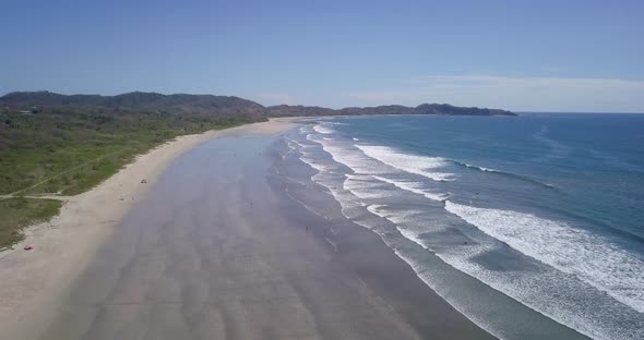 Aerial drone view of the beach, rocks and tide pools in Guiones, Nosara, Costa Rica.