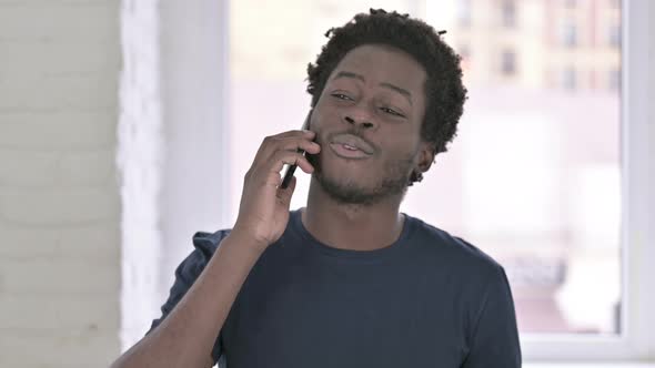 Portrait of Cheerful Young African American Man Talking on Smartphone