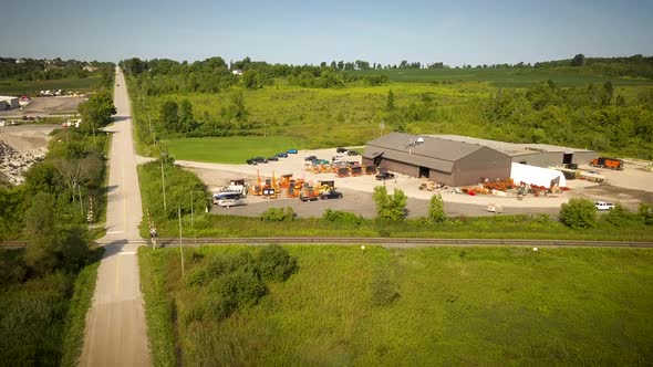 Drone flying over an industrial complex in a rural area.