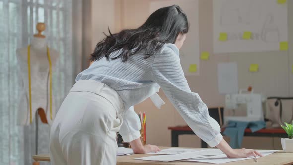 Back View Of A Woman Designer Arranging The Bag Sketching Layout Bond At The Office