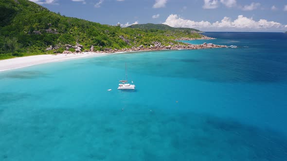 Aerial View Footage of Lonely Luxury Catamaran Yacht Moored in Crystal Clear Turquoise Blue Ocean