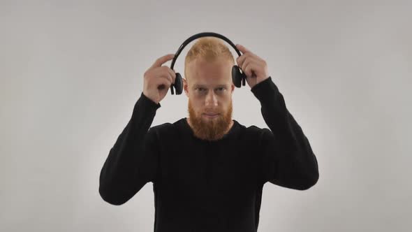 A Very Cheerful Redheaded Guy with a Beard, Dresses His Headphones and Listens To Music