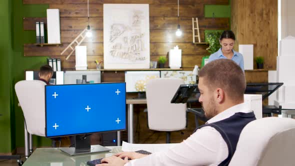 Young Architect Working on a Computer with Blue Screen