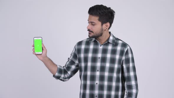 Young Happy Bearded Indian Man Showing Phone and Giving Thumbs Up