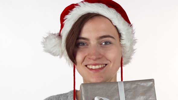 Attractive Christmas Woman Hiding Her Face Behind a Present Box