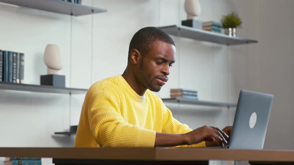Young man surfing the internet using laptop ast home. Young man with laptop in apartment