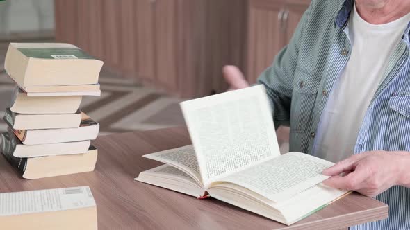 Senior Man with Mustache Reading a Book