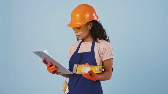 Darkskinned Woman Worker in Hard Hat Protective Goggles and Gloves