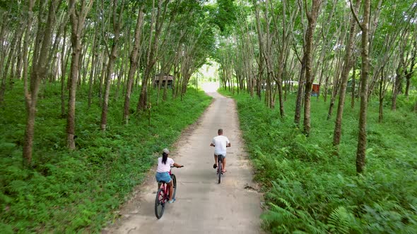 Couple Men and Women on Bicycle at a Rubber Plantation in Thailand