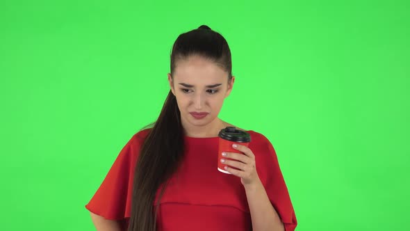 Portrait of Pretty Young Woman Is Drinking Unpalatable Coffee and Is Disgusted. Green Screen