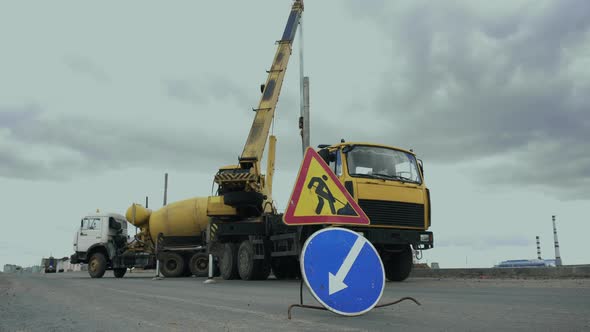 Workers Install a Pole with Street Light By Automobile Crane Along the Road. Construction Machinery