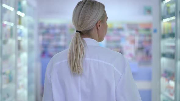 Tracking Shot of Confident Caucasian Woman Walking in Drugstore Looking Around in Slow Motion