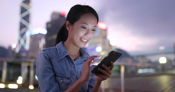 Woman looking at cellphone in the street