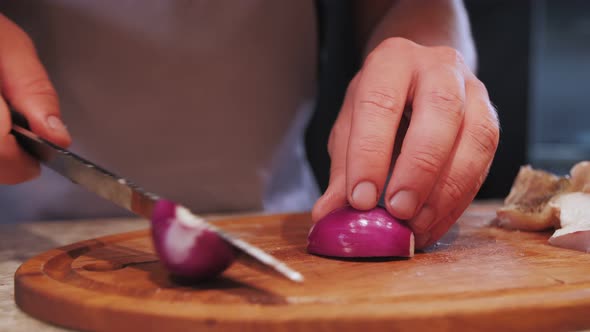 cutting red onions on a wooden board