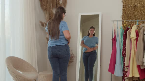 Plump Lady Looking on Reflection Checking Fat Fold on Belly Indoors