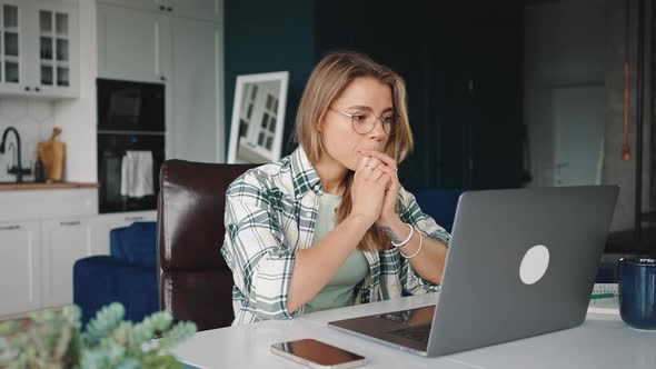 Zoom Out Portrait of Young Blonde Lady Typing on Laptop Reading Info on Computer Screen and Enjoying