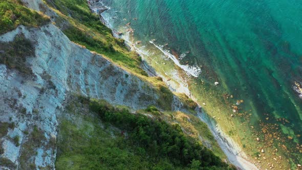 Aerial View of Rocky Coastline Down Blue Sea Deep White Cliffs