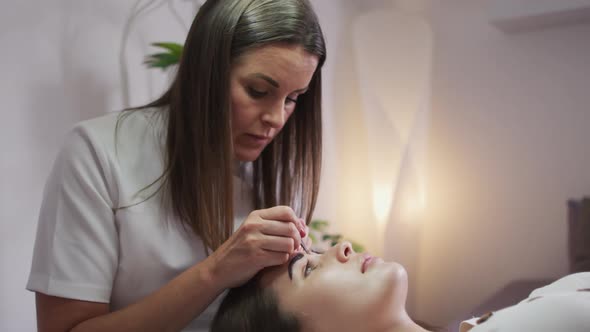 Caucasian woman lying down having her eyebrows dyed