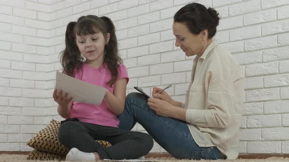 Mother draw with her daughter. 