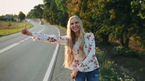 Traveler Girl Hitchhiking on a Sunny Road and Walking.