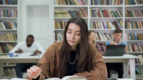 Woman with Long Hair which Sitting in the Library and Reading book alt